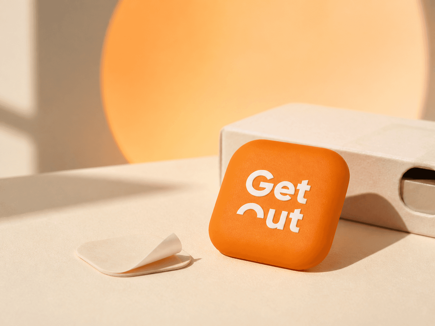 Product concept of the orange GetOut tag, mounting strip and cream packaging